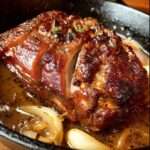 Rouelle de porc confite au four nappée d’une sauce aux oignons et à l’ail