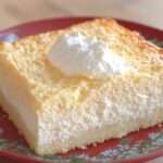 Part de gâteau magique à la vanille montrant ses trois couches distinctes sur une assiette.