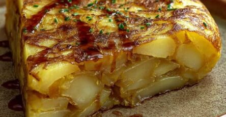 Tranche de tortilla espagnole dorée aux pommes de terre et oignons, servie sur une assiette rustique.