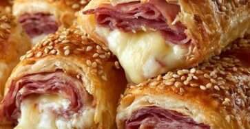 Roulés feuilletés au jambon et fromage dorés et croustillants sur une plaque