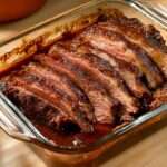 tranche de brisket de bœuf braisé nappée de sauce tomate‑vin
