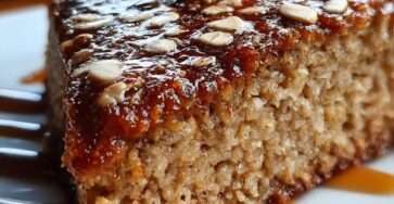 Gâteau diététique coupe-faim aux flocons d’avoine, moelleux et doré, préparé sans sucre ajouté, tranché sur une planche en bois avec bananes et avoine.