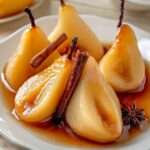 poires pochées au miel et à la cannelle servies chaudes avec leur sirop doré, décorées d’un bâton de cannelle et d’une étoile de badiane.