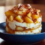 Tiramisu au caramel beurre salé garni de pommes poêlées à la cannelle, présenté en verrines avec cacao saupoudré.