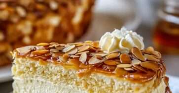 Gâteau allemand Bienenstich coupé en parts, avec crème vanillée au mascarpone, pâte briochée moelleuse et croûte dorée d’amandes au miel.