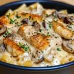 Gratin de pâtes au poulet et champignons doré au four, nappé de sauce crémeuse et parsemé de fromage fondant et de persil frais.