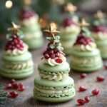 Macarons de Noël en forme de petits sapins composés de coques vertes superposées et décorés de grains rouges et d’une étoile sucrée.