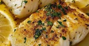 Filets de cabillaud au citron et à l’ail cuits au four, nappés d’une sauce au beurre, huile d’olive et persil, garnis de rondelles de citron et servis dans un plat familial.