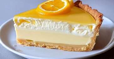 Tarte crémeuse aux agrumes avec glaçage citron orange brillant et décoration de tranches d’agrumes.