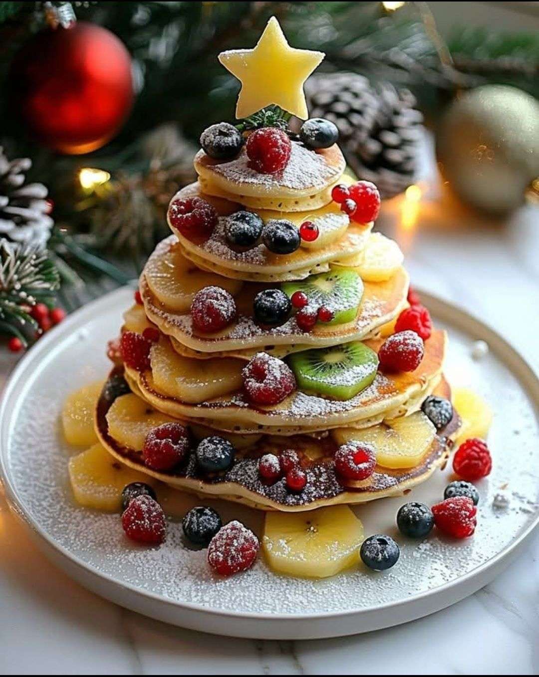 pancakes en forme de sapin de Noël décorés de fruits rouges et bananes sur assiette festive