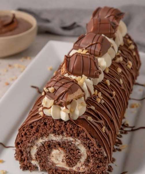 Photo d’un roulé suisse au Nutella fait maison, délicatement saupoudré de sucre glace, avec une génoise moelleuse et une garniture généreuse à la pâte à tartiner.
