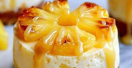 Mini cheesecakes individuels renversés à l’ananas avec caramel coulant sur le dessus, servis en dessert élégant.