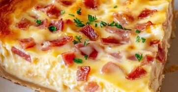 Quiche lorraine dorée avec lardons, appareil crémeux et pâte croustillante, servie tiède avec persil.