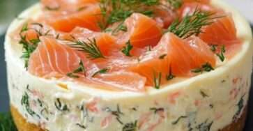 Cheesecake au saumon fumé en portion individuelle, sur base de biscuits salés, décoré de saumon et ciboulette.