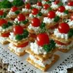 Mini millefeuilles salés composés de crackers croustillants, fromage frais et tomates cerises en décoration.