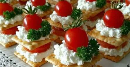 Mini millefeuilles salés composés de crackers croustillants, fromage frais et tomates cerises en décoration.