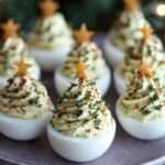 Œufs mimosa dressés en forme de sapin de Noël sur un plat festif.