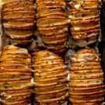 Pommes de terre Hasselback croustillantes au four, dorées, garnies d’ail, d’herbes et de beurre fondu.