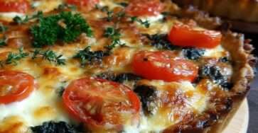 Tarte salée rustique aux épinards fondants, tomates cerises rôties et fromage gratiné doré au four, servie en parts généreuses.