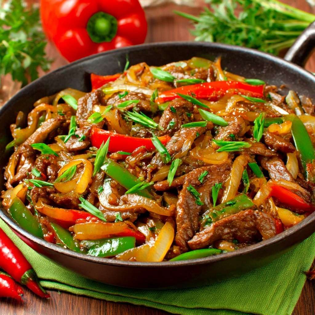 Wok de bœuf sauté aux poivrons rouges et verts et oignons fondants, nappé de sauce soja brillante et servi chaud dans un wok.
