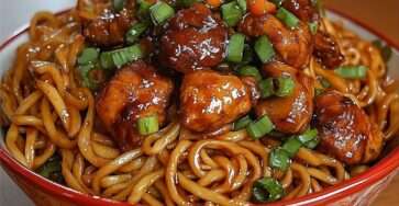 Nouilles sautées au wok avec boulettes de poulet caramélisées, sauce soja brillante, oignons verts et légumes croquants