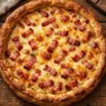 Quiche aux lardons dorée au four, pâte brisée croustillante garnie de lardons fumés, crème, œufs et fromage fondant.