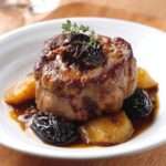 Paupiettes de veau farcies aux pruneaux nappées de sauce brune brillante, servies bien chaudes avec accompagnement rustique.