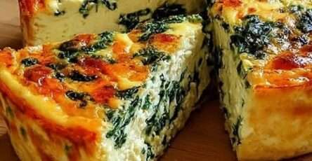 Gâteau salé aux épinards sans pâte, texture fondante et dorée sur le dessus, tranché et servi sur une assiette avec une salade verte en accompagnement.