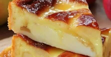 Flan aux pommes et yaourt ultra fondant, texture crémeuse et moelleuse avec morceaux de pommes dorés, servi sur une assiette blanche avec une légère caramélisation en surface