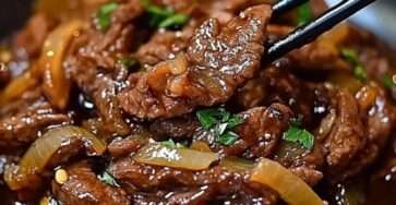 Bœuf sauté à l’oignon en fines lamelles, sauce soja brillante, oignons fondants et garniture d’oignons verts dans un wok