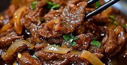 Bœuf sauté à l’oignon en fines lamelles, sauce soja brillante, oignons fondants et garniture d’oignons verts dans un wok