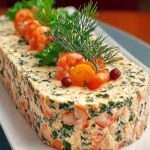 Terrine de saumon et crevettes tranchée, texture fondante rosée avec morceaux visibles de crevettes et herbes fraîches, servie sur un plat élégant