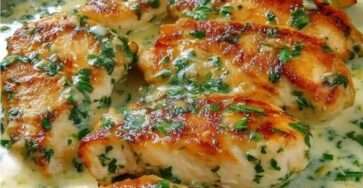 Filets de poulet crémeux dorés nappés d’une sauce crémeuse à l’ail et au persil frais, servis dans une poêle avec une texture onctueuse et brillante