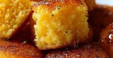 Bouchées de cornbread dorées et moelleuses, servies chaudes avec un nappage brillant au miel et au beurre, dans un moule à mini muffins.