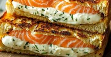 Croque-monsieur au saumon et Boursin doré à la poêle, pain croustillant, crème fondante aux herbes et garniture de saumon servi chaud.