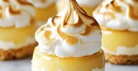 Mini cheesecakes au citron avec base biscuitée croustillante et meringue dorée légèrement caramélisée sur le dessus.