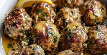 boulettes de dinde dorées au four nappées d’une sauce citronnée au beurre avec persil frais dans une assiette