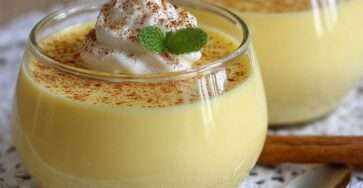 Verrines de crème dessert vanille maison onctueuse garnies de chantilly, saupoudrées de cacao et décorées de feuilles de menthe.