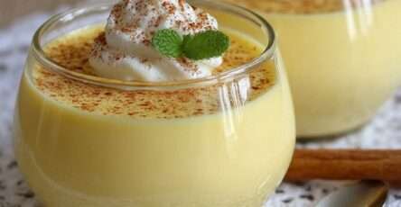 Verrines de crème dessert vanille maison onctueuse garnies de chantilly, saupoudrées de cacao et décorées de feuilles de menthe.