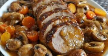 Filet mignon de porc tranché nappé de sauce brune avec champignons fondants et carottes, servi chaud avec persil frais.