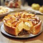 Gâteau fondant aux pommes et mascarpone, texture moelleuse avec tranches de pommes dorées sur le dessus et sucre glace.