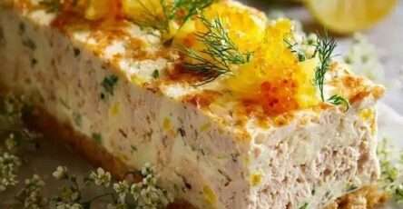 Terrine de poisson citronnée aux herbes, texture lisse et crémeuse, garnie de citron et d’aneth, servie en tranches.