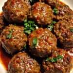 Boulettes de viande nappées de sauce tomate épicée, servies chaudes avec persil frais et sauce onctueuse.