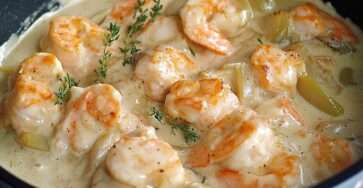 Blanquette de Saint-Jacques et crevettes servie chaude avec sauce crémeuse, persil frais et accompagnement de riz blanc.