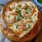 Pain farci croustillant garni de crevettes crémeuses au fromage fondu, gratiné au four avec persil frais et texture dorée appétissante.