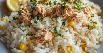 Assiette de riz au thon, maïs et citron avec persil frais ciselé, servie dans un bol clair pour un repas rapide et léger.