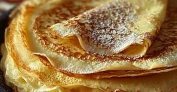 Pâte à crêpes fines et dorées empilées, préparées maison, avec une texture légère et moelleuse, servies pour un goûter gourmand.