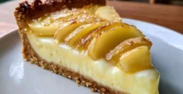 Tarte aux pommes et mascarpone dorée avec fines tranches de pommes disposées en rosace sur une crème onctueuse, servie sur une pâte sablée croustillante.