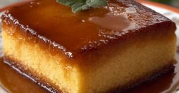 Gâteau au caramel fondant démoulé avec un nappage caramel brillant coulant sur le dessus, texture moelleuse et dorée, servi en parts.