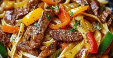 Nouilles sautées au bœuf avec poivrons colorés, oignon et herbes fraîches, servies chaudes dans un wok.